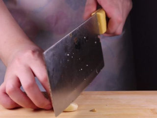 5、教你一个茄子的新吃法,又香又好吃一看就会,取几颗大蒜,将大蒜剁成肉末备用。取两条茄子,将茄子去蒂。