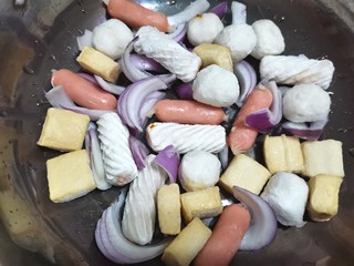 10、部队火锅,锅底依次放入洋葱，鱼豆腐，包心鱼卷，鱼丸，香香肠