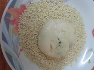 13、蟹壳黄烧饼,把饼坯表面刷蜂蜜水沾满芝麻