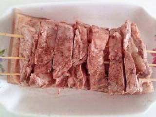 12、脆皮烧肉,  抹好后在肉的一面插入竹签，必须是插在肉的中间；以免烤的时候肉会卷起。