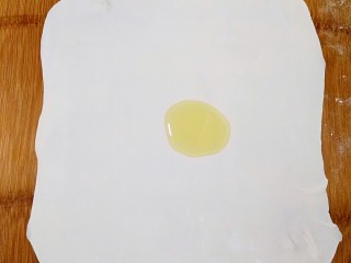 7、做饼+手抓饼,在擀开的面剂上倒适量的橄榄油。