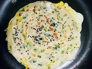 17、做饼+手抓饼,等鸡蛋半凝固时翻面，让鸡蛋面朝下，稍微一烙就可以出锅了。