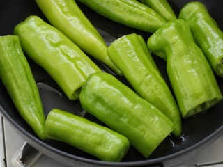 5、虎皮尖椒,锅中倒少许食用油，然后放入尖椒段小火煎制