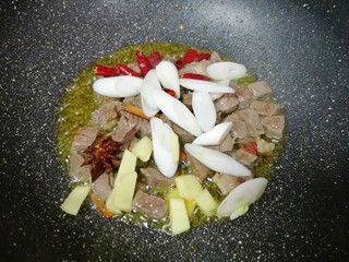 7、土豆烧牛肉,下入葱、姜、干红辣椒、八角和桂皮炒香。