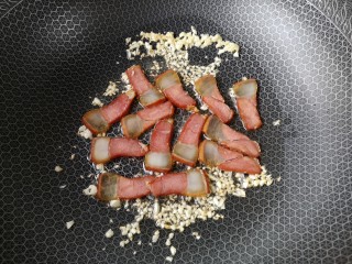 8、腊味芦笋,下入腊肉，翻炒至肥肉部分变得透明。
