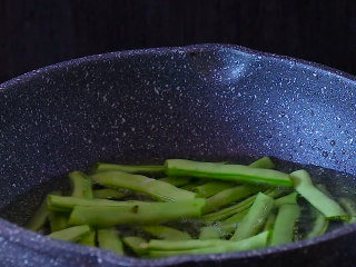 4、干煸四季豆,放入已经摘成段的四季豆，注意喽四季豆一定不能有水，以免溅油，后果就不开设想啦。