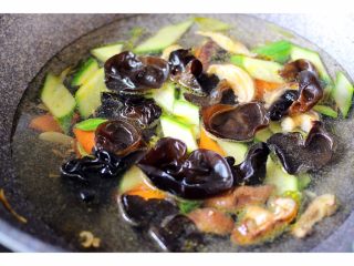 11、扇贝海鲜杂蔬羹,加入适量的清水、放入木耳、大火烧开后转小火慢慢煮2分钟