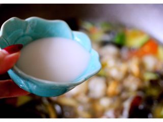 14、扇贝海鲜杂蔬羹,淀粉加入30克清水搅匀后、慢慢倒入锅中搅匀……