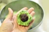 7、艾草青团,揪一个小剂子，包入豆沙馅，推包住豆沙馅。