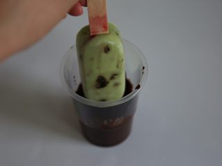 15、牛油果脆皮雪糕,把巧克力倒入一个长高的杯子里，手温时候即可放入牛油果雪糕进去