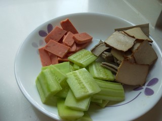 4、川味麻辣毛血旺,黄瓜去皮切成片，火腿肠切成片，香干切成片。