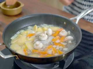 9、奶油炖菜,接着倒入热水没过所有的蔬菜，木鱼花汤包和口蘑也放进去，小火炖煮