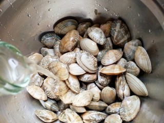 11、蒜蓉蒸大虾,洗干净的花甲倒入一勺料酒，搅拌均匀