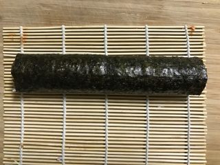 5、快手紫菜包饭,借助寿司帘卷好。