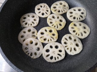 6、回锅藕片,将切好的藕片码入锅中，中火煎至一面微金黄。