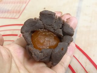 7、广式豆沙蛋黄月饼,分好的豆沙一个个把咸蛋黄包好收口，搓圆