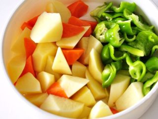 5、土豆炖牛仔骨,将胡萝卜和土豆切成小块备用。青椒斜切小块。