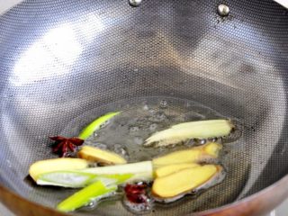 6、土豆炖牛仔骨,锅里放油加热，小火倒入姜片、八角、大葱爆炒。