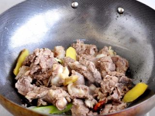 7、土豆炖牛仔骨,加入牛仔骨，慢炒出水分，肉炒至微黄即可。