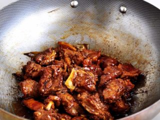 8、土豆炖牛仔骨,放入干辣椒、牛肉酱、继续翻炒均匀后，依次再加入料酒，生抽，老抽，让酱料翻炒均匀入味。