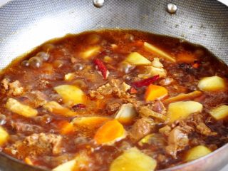 10、土豆炖牛仔骨,待水与牛仔骨基本齐平的时候，加入土豆和胡萝卜，适量加盐，继续大火收汁。
