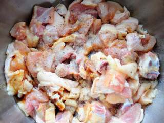 2、家常干煸辣子鸡（微辣版） 宴客必备硬菜 百分百复制饭店口味,把鸡腿切中等大小块儿，炸的过程中鸡块会缩小，所以切的时候切的太小的话炸出来就太小了不好看，切大了腌制的时候不容易入味，还不容易炸透。切成3×3厘米大小的就差不多。切好的鸡块还是有些血水的，我习惯用清水再冲洗两遍。鸡块沥干水后加盐、生抽、白胡椒粉（去腥）、黑胡椒粉（去腻增香）、料酒（去腥）、糖（提味）。如果家里有大蒜粉和洋葱粉，可以各少放小半勺，炸出来的鸡肉风味更佳，没有就不放。放好腌制用的调料后，下手拌匀，腌制半小时以上直至入味。这道菜的味道在这一步骤就调好了，炸过之后鸡丁的表壳是酥脆的，再加调料的话也难以入味了。