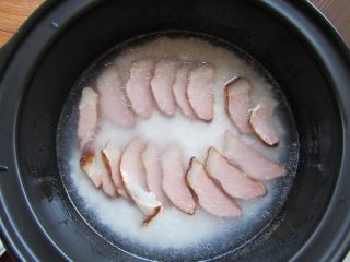 8、腊肉煲仔饭,把腊肉铺在表面，加入料酒，加盖焖煮