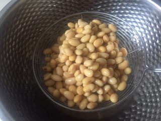 2、自制爽滑豆花,倒掉水，用漏筛控干水份。