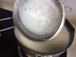 5、自制爽滑豆花,煮的过程可以用面筛把上面的浮沫撇去。