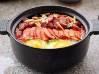 12、腊肠煲仔饭,放姜丝，码上香肠并打两个鸡蛋进去。