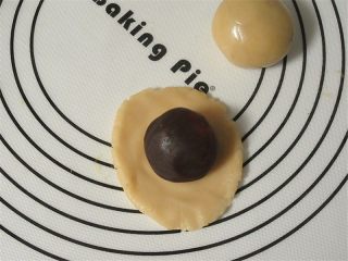 6、教你不用模具也可自制纯手工DIY月饼,随便取适量一小块的皮在手中捏扁，放上馅料，用虎口小心的把面皮往上推，整理好收口，不能有缝隙，并搓圆。