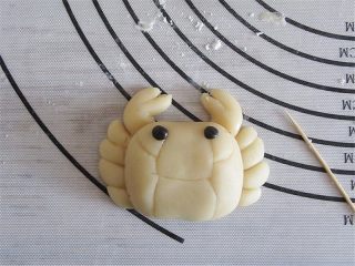 9、教你不用模具也可自制纯手工DIY月饼,把身体放在排放好的蟹脚上，轻轻按压一下，眼睛可以用黑豆，也可以用可可粉加少量皮揉出来，若喜欢黑黑的眼睛，可以用少许皮加黑碳粉，也还可以暂时不