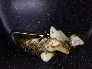 11、孜然羊肉卷,放入蒜片和另一半孜然,少倒一点点生抽炒香