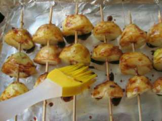 5、香烤土豆串,把土豆串上面均匀的刷上烤肉酱。