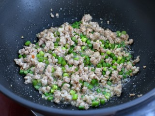 7、炸酱面,接着放入蒜苔丁和姜末翻炒均匀