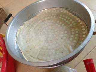 8、潮汕冬至过年美食之【菜头圆】,拿来一个大蒸笼和铺上炊布。(由于菜头圆形状不固定,铺上炊布是为了防止菜头圆有些从蒸笼孔中流出,出锅后的菜头圆就会变得很丑了呢。)