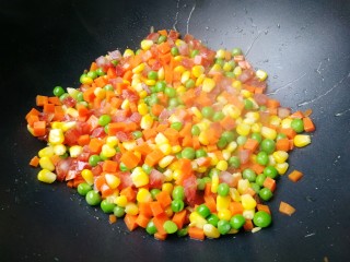 7、蛋包饭,锅里放油，放入玉米粒，红萝卜丁，青豆，腊肠丁一起放进去炒香，放适量的盐和酱油