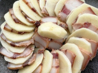 3、腊肉蒸土豆,一片土豆，一片腊肉，这样的摆成圆形，多余的放中间。