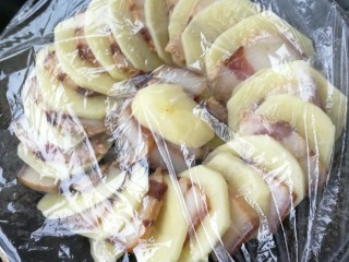 4、腊肉蒸土豆,在保鲜膜上锅蒸20分钟。