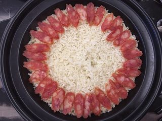 8、腊肠砂锅煲仔饭,铺好食材，可以围着一圈，也可以一边一边放，随意