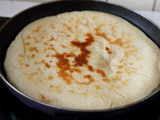 8、先煎后烤披萨,15.翻面盖锅煎烙。17.感觉不满意可再翻一次面，不用盖锅盖略煎一会就可。