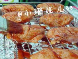 4、新奥尔良烤翅,烤盘铺上锡纸。将腌制好的鸡翅码在烤架上，用刷子将剩余的酱料涂抹在鸡翅上