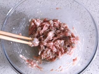 10、鲜虾时蔬小馄饨,倒入除虾油外的所有材料，用筷子顺着一个方向搅拌肉馅，直至肉馅出筋的状态
