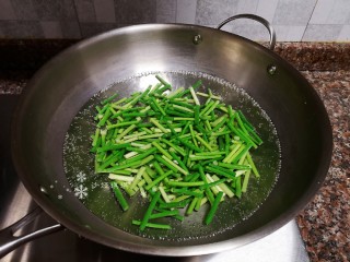 4、蒜苔炒牛肉,蒜苔先放入锅中煮1分钟捞出。