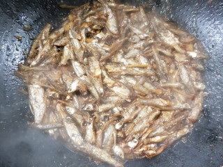 11、香辣下饭菜～客家小炒鱼干,延边缘浇一点料酒，继续翻炒一会，切记中火。