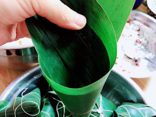 6、红豆粽子,卷起成一个漏斗形状。