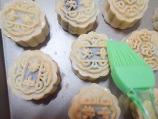 12、广式莲蓉蛋黄、豆沙蛋黄月饼制作方法,取出每次都晾凉5分钟，刷上蛋黄液+水（或全蛋液+水），记住表层蛋黄液别刷太多，最好用羊毛刷比较好控制蛋液量，蛋液只刷在花纹最上面凸出来的那部