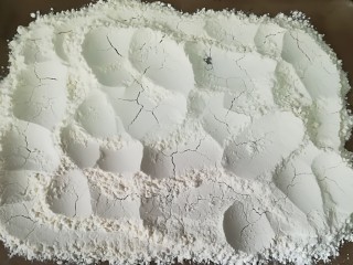 4、云腿月饼,面粉铺在烤盘上，放入烤箱中层，150度烘烤至微微泛黄结块即可，如图所示