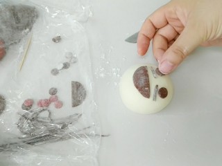 14、萌萌哒哒小麦馒头,放上眼睛,不要摁太狠,把面团表皮摁破,蒸出的馒头表皮就不光滑啦。