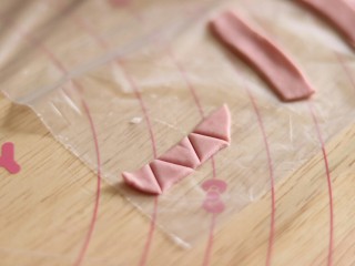 12、网红猪猪汤圆/花纹汤圆,做猪猪汤圆,把红色搞成面片,划成条,再划出三角形。